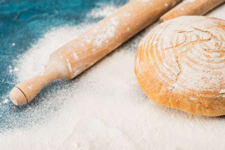 fresh baked bread and wooden rolling pin on flour