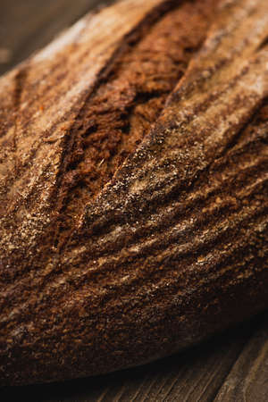 close up view of fresh baked bread loaf on wooden surface
