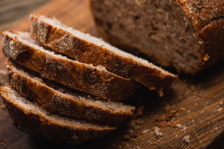 close up view of fresh baked bread slices on wooden cutting boardの写真素材