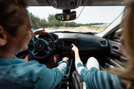 Selective focus of woman pointing with finger while husband driving car