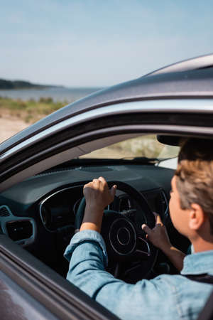 Selective focus of man driving auto during vacation