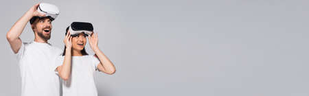 website header of excited interracial couple in white t-shirts looking away with open mouths while...