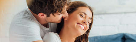 Horizontal crop of man looking at girlfriend with closed eyes at home