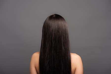 back view of naked brunette long haired woman isolated on blackの写真素材