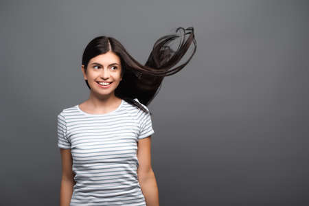 brunette long haired woman smiling isolated on blackの写真素材