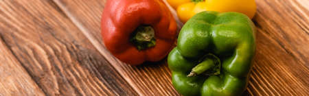 colorful ripe bell peppers on wooden table, panoramic shotの写真素材