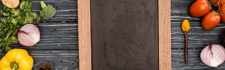 top view of fresh colorful vegetables and empty chalkboard on wooden table, panoramic shotの写真素材