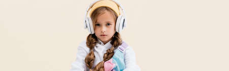 blonde girl in sportswear and headphones isolated on beige, panoramic shotの写真素材