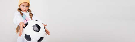 blonde girl in sportswear posing with soccer ball isolated on white, panoramic shotの写真素材