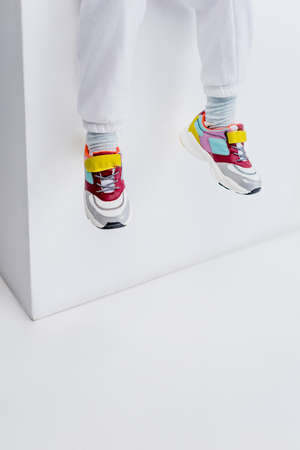 cropped view of girl in sneakers on white backgroundの写真素材