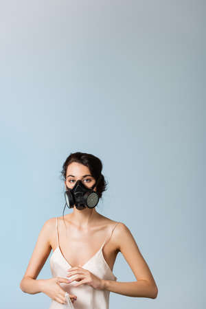 brunette woman in gas mask holding plastic bag isolated on gray, ecology conceptの写真素材