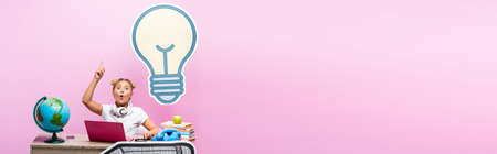 Panoramic shot of excited girl having idea near gadgets, globe and paper art on pink background