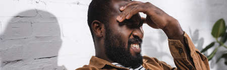 Panoramic shot of african american man touching head