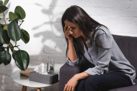 Selective focus of woman sitting on couch near coffee table with napkinsの写真素材