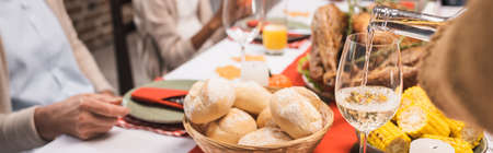 selective focus of delicious buns, corn and glass of white wine on table, served on thanksgiving day...