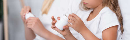 Website header of girl holding jar with pills near woman at home