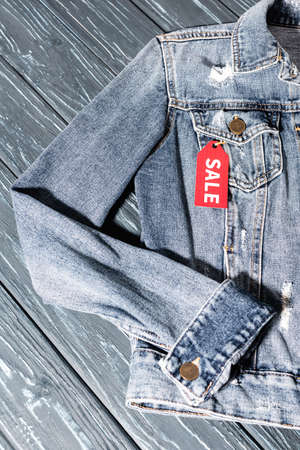 top view of red sale tag on blue denim jacket, black friday concept