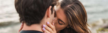 Website header of woman kissing boyfriend on sea coastの写真素材