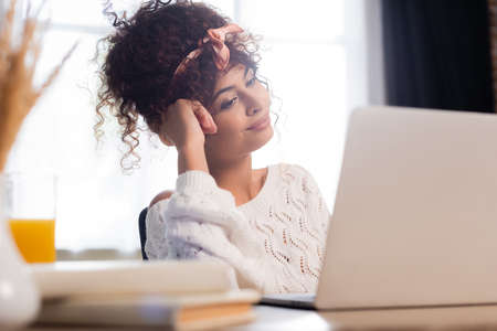 selective focus of pleased woman looking at laptop