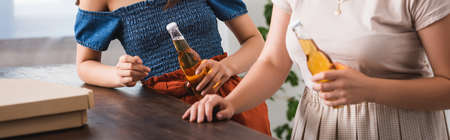 cropped view of young women holding beer during party, panoramic conceptの写真素材