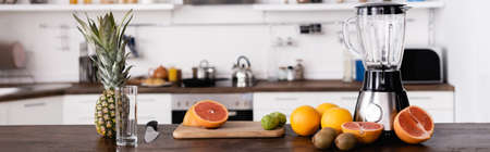 Panoramic shot of fresh fruits near blender on table in kitchenの写真素材