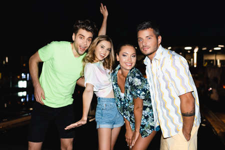 Young friends looking at camera outdoors at night