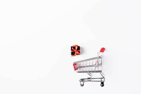Top view of small shopping cart and gift box on white backgroundの写真素材