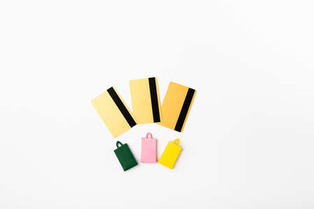 Top view of small shopping bags and credit cards on white background