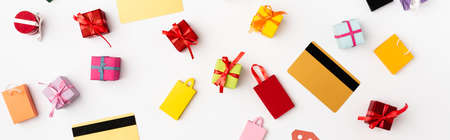 Panoramic orientation of credit cards and toy shopping bags and gifts on white backgroundの写真素材