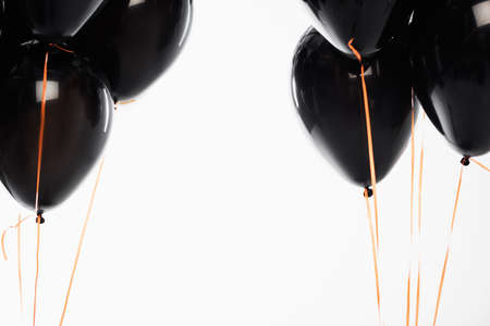 Black festive balloons with strings isolated on whiteの写真素材