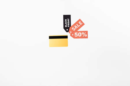 Top view of credit card near price tags with black friday and sale lettering on white backgroundの写真素材