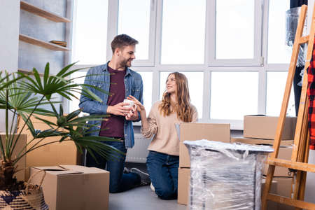 man and woman looking at each other while unpacking carton boxes in new home