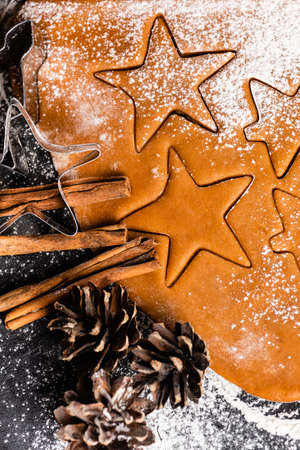 Top view of cookies shapes with pine cones and cinnamon sticks