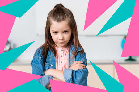 Serious schoolgirl with crossed arms looking at camera near colorful triangles illustration