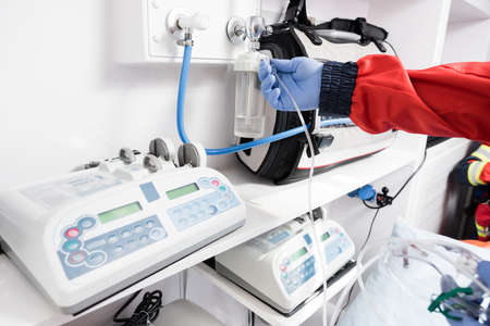 Cropped view of paramedic holding tube of nebuliser in ambulance car