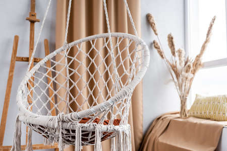 Modern studio interior with hanging chair and easelの写真素材