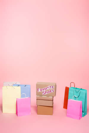 carton box with favorite shoes lettering near shopping bags on pink, black friday conceptの写真素材