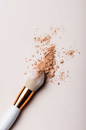 top view of cosmetic brush with face powder on beige backgroundの写真素材