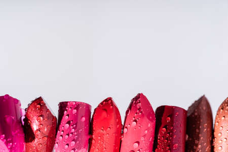 close up view of wet lipsticks in row isolated on whiteの写真素材