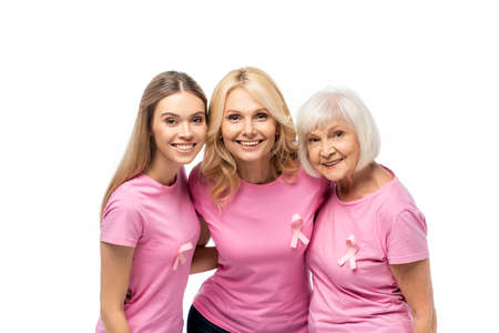 Women with ribbons of breast cancer awareness embracing and looking at camera isolated on whiteの写真素材