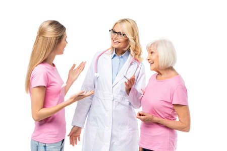 Young woman with pink ribbon on t-shirt pointing with hands near doctor isolated on whiteの写真素材