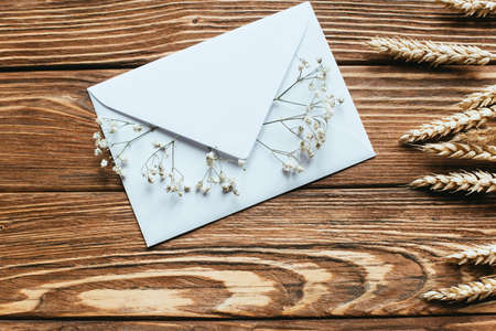 top view of envelope with dry wildflowers on wooden background