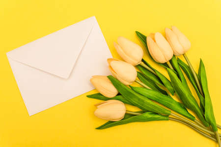 top view of envelope near tulips on yellow backgroundの写真素材