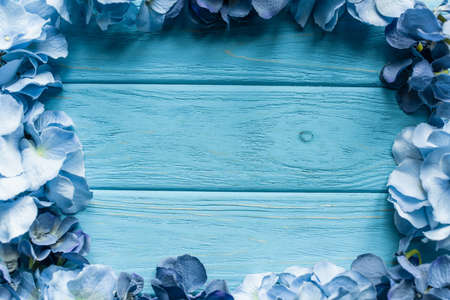 top view of wooden blue background with floral frame