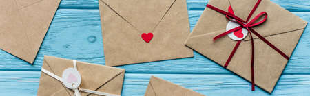 top view of wooden blue background with envelopes and hearts, panoramic shot