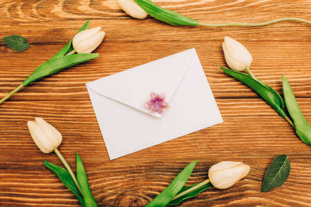 top view of envelope near tulips on wooden backgroundの写真素材
