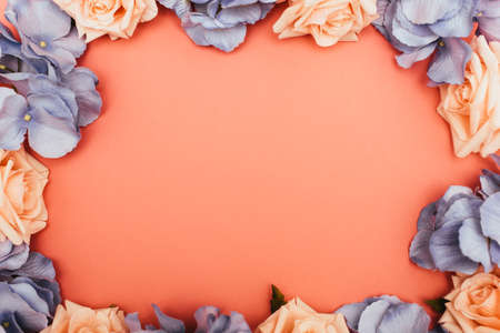 top view of floral frame on coral background