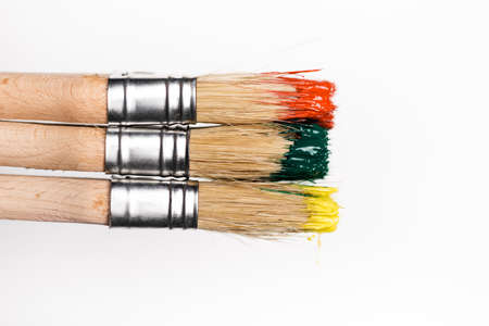 top view of paintbrushes with colorful paint on white backgroundの写真素材