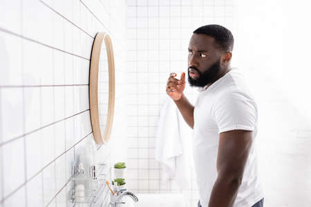 afro-american man looking at face in mirror