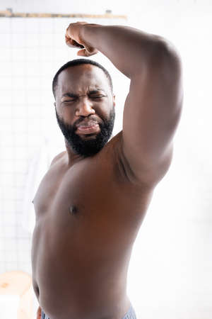 afro-american man putting hand up and grimacing from bad smellの写真素材